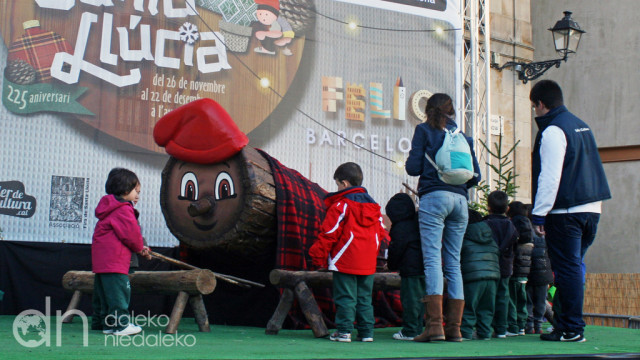 Dzieci uderzają kijkami Tió de Nadal czekając na drobne upominki Dzieci uderzają kijkami Tió de Nadal czekając na drobne upominki